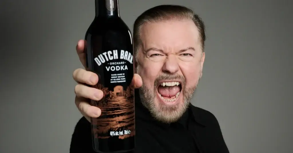 Ricky Gervais holding a bottle of Dutch Barn Vodka