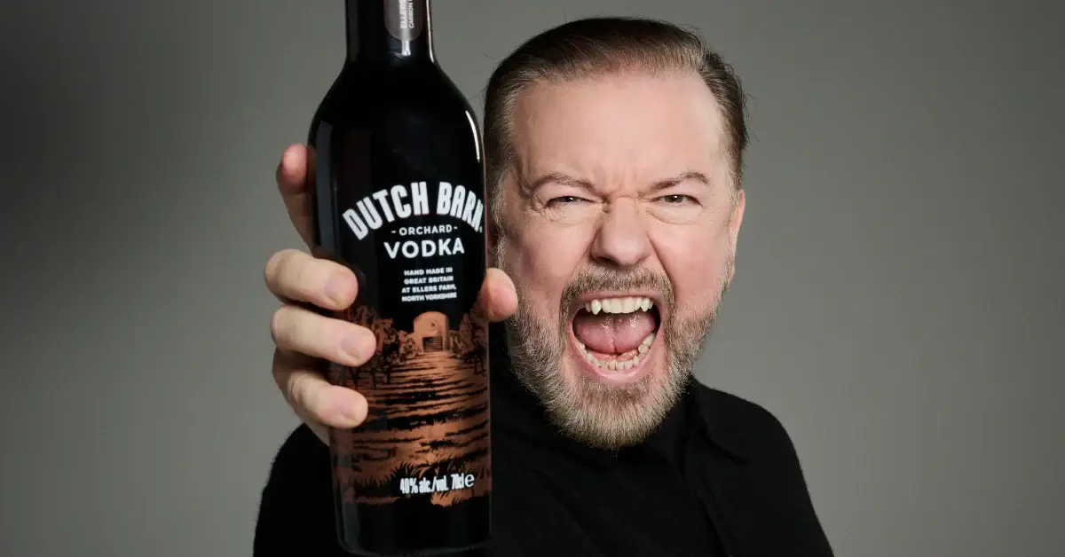 Ricky Gervais holding a bottle of Dutch Barn Vodka