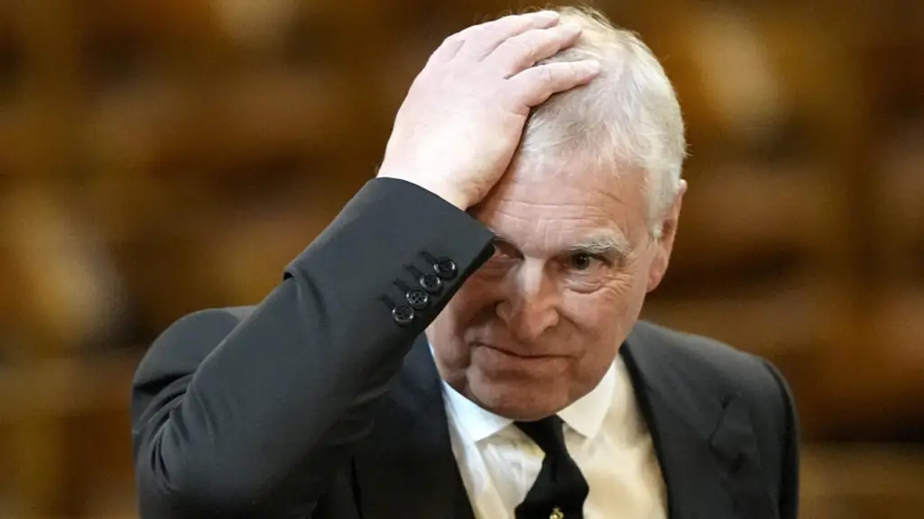 Andrew Mountbatten-Windsor with his hand on his head